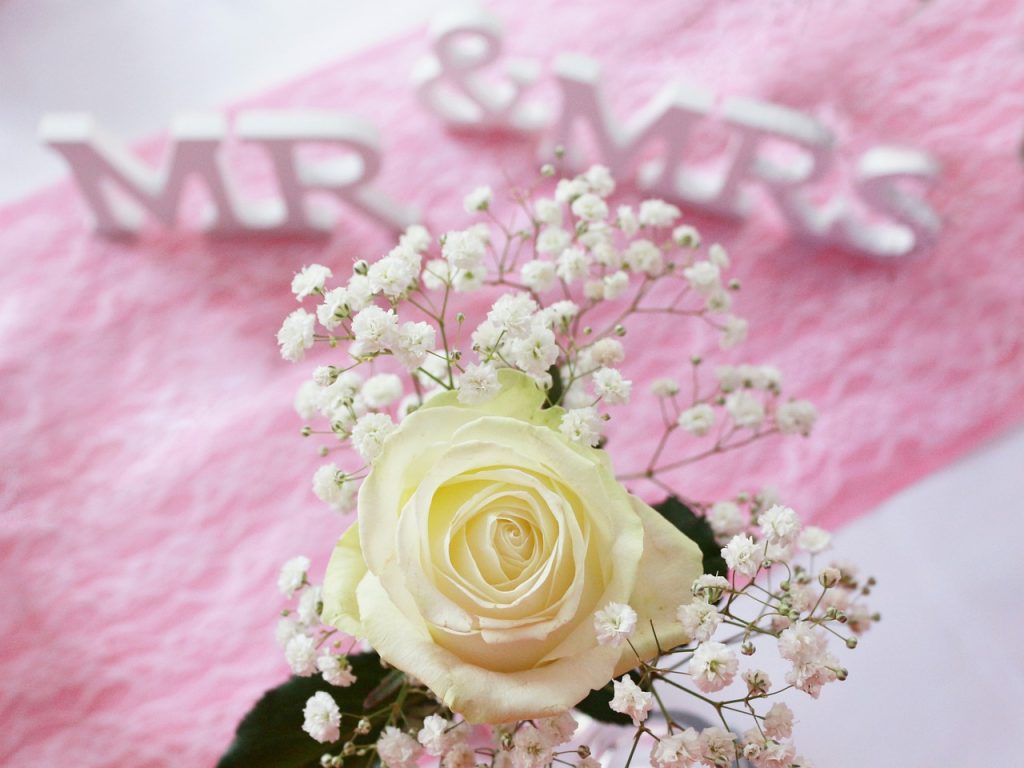 Gestaltung Brauttisch mit Blumenarrangement und Holzschildern 