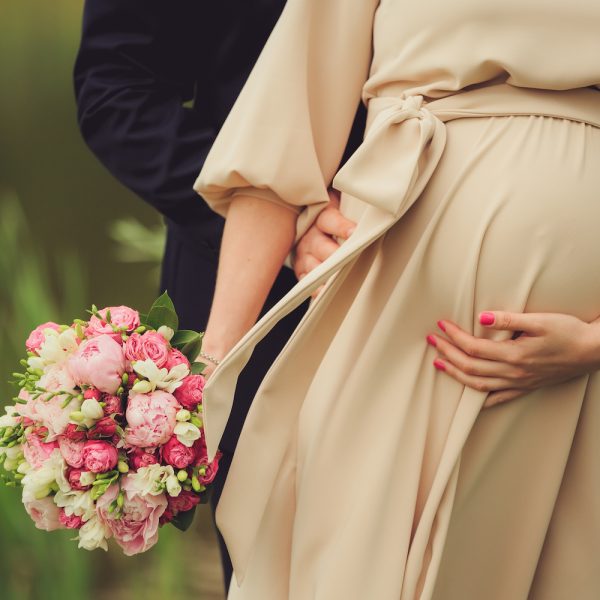 Schwanger heiraten - Ehemann umarmt seine schwangere Ehefrau