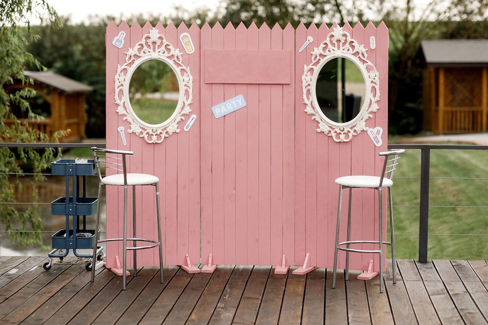 Rosafarbene DIY-Holzwand mit weißen Bilderrahmen als Fotoecke zur Hochzeit