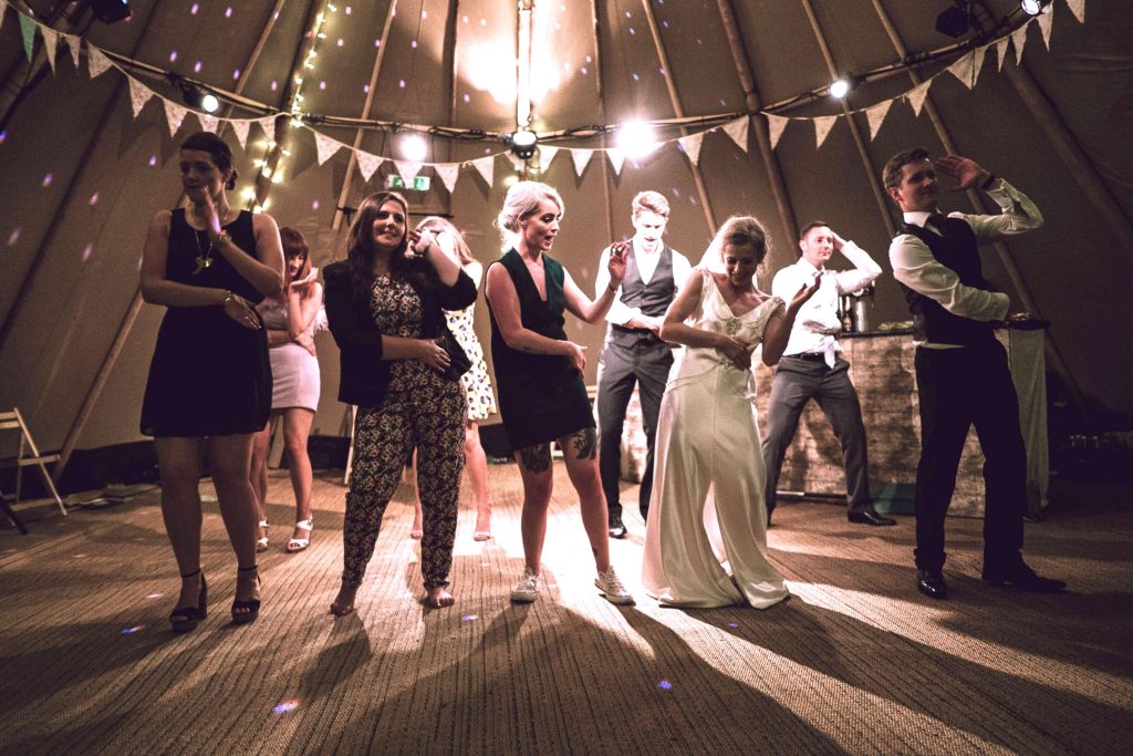 Brautpaar tanzt mit Gästen auf der Hochzeit im Partysaal